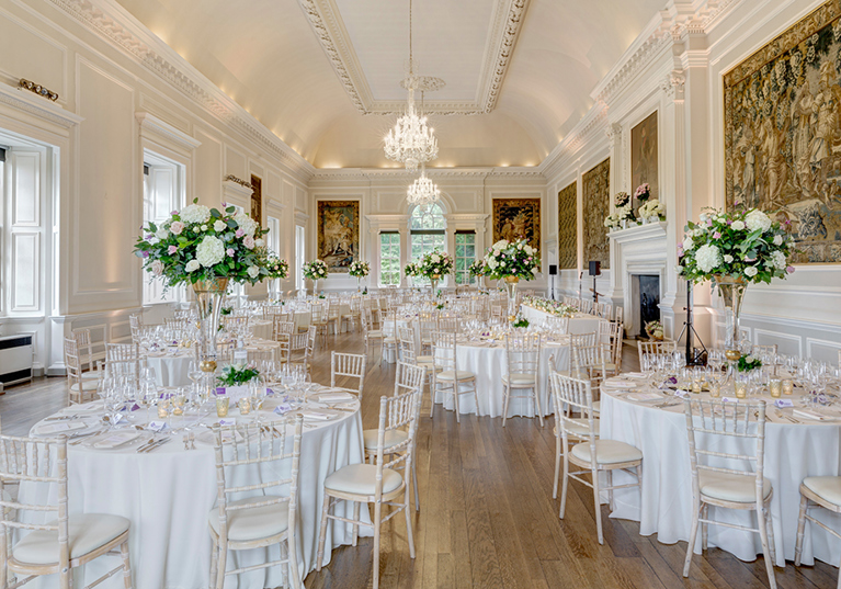 White colour scheme wedding meal with large bouquets of cream flowers as centrepieces